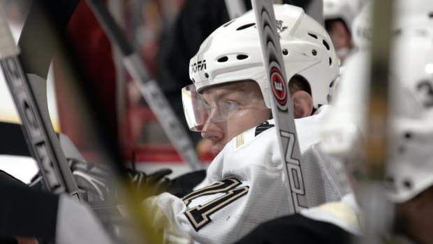 Former Penguins winger Konstantin Koltsov looks on from the bench during a game.